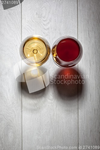 Image of Glasses of red and white wine on wooden table
