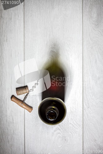 Image of Bottle of red wine with cork on white wooden table