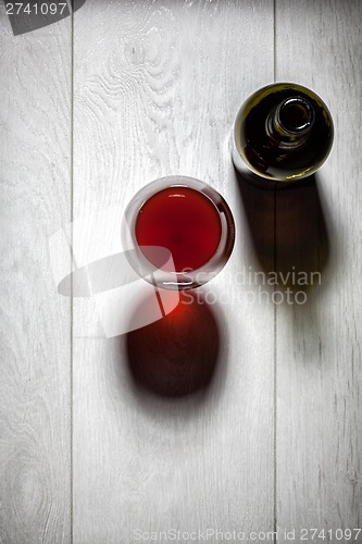 Image of Glass and bottle of red wine with cork on table