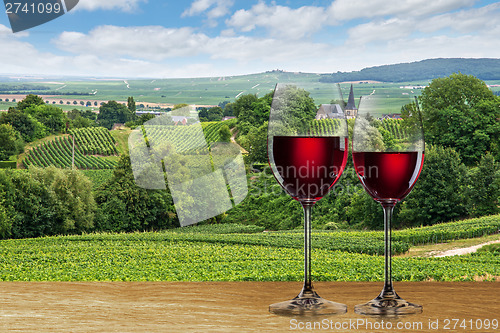 Image of Glass of red wine against vineyard
