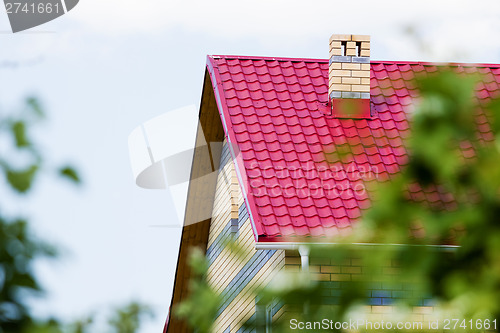 Image of Red roof house on a background of the summer sky