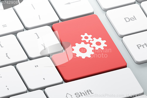 Image of Web development concept: Gears on computer keyboard background