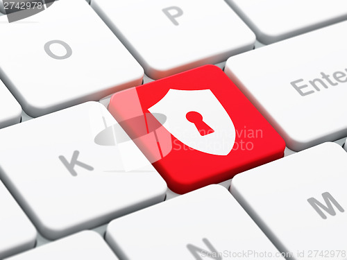 Image of Protection concept: Shield With Keyhole on computer keyboard bac