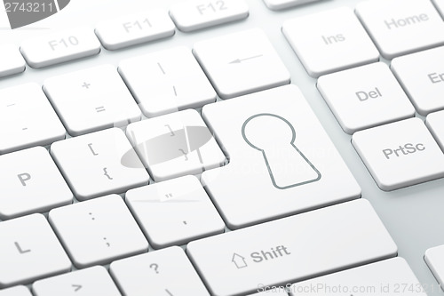 Image of Security concept: Keyhole on computer keyboard background