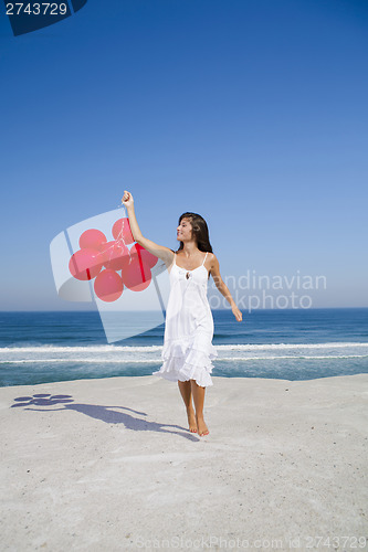 Image of Beautiful girl running with red ballons