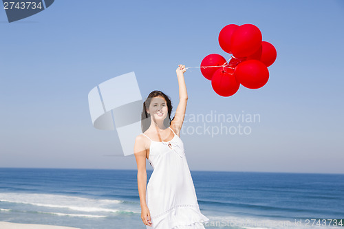 Image of Beautiful girl holding red ballons