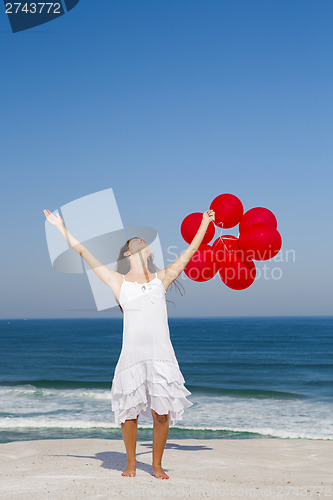 Image of Beautiful girl holding red ballons