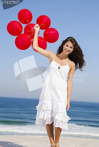 Image of Beautiful girl holding red ballons