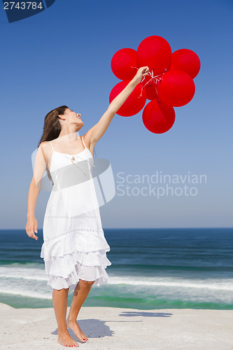 Image of Beautiful girl holding red ballons