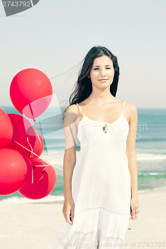 Image of Beautiful girl holding red ballons