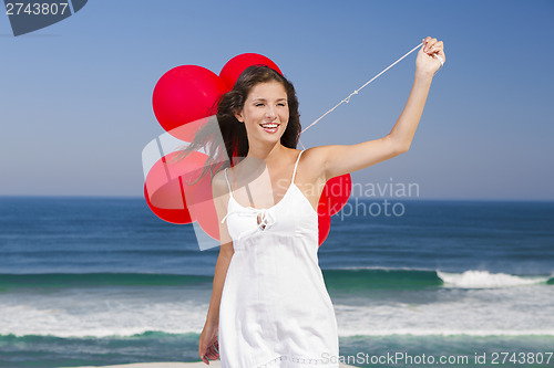 Image of Beautiful girl holding red ballons