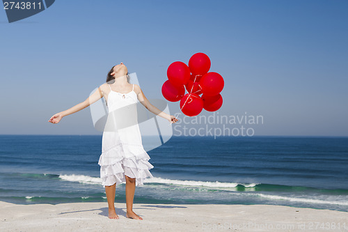 Image of Beautiful girl holding red ballons