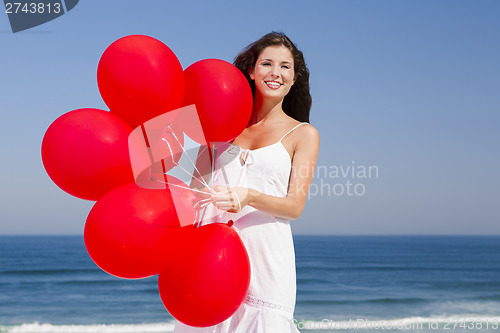 Image of Beautiful girl holding red ballons