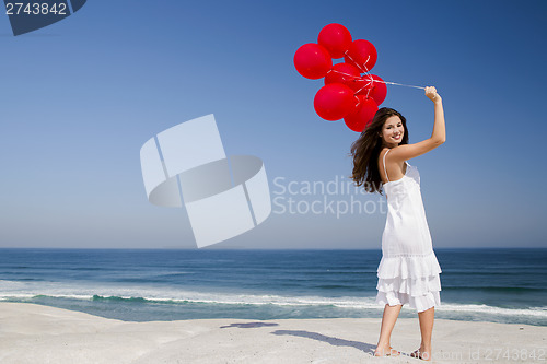 Image of Beautiful girl holding red ballons