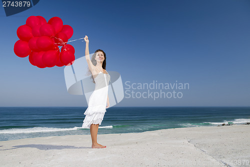 Image of Beautiful girl holding red ballons