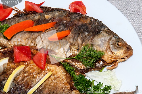 Image of Fresh crucian river fish fried in lemon juice and fresh herbs.