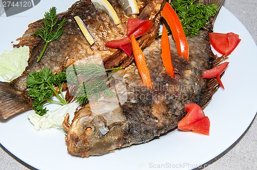 Image of Fresh crucian river fish fried in lemon juice and fresh herbs.