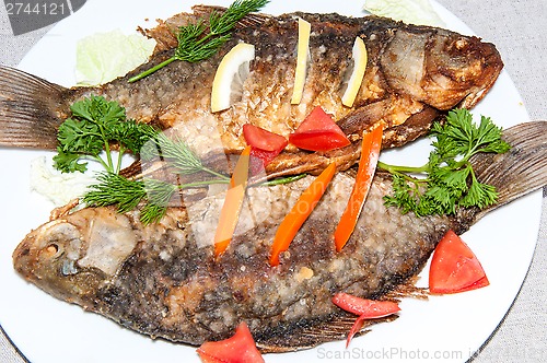 Image of Fresh crucian river fish fried in lemon juice and fresh herbs.