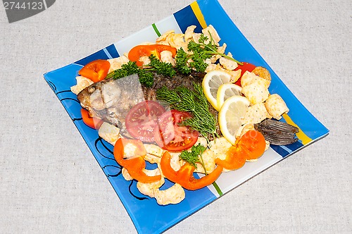 Image of Fresh crucian river fish fried in lemon juice and fresh herbs.