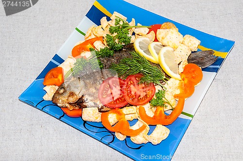 Image of Fresh crucian river fish fried in lemon juice and fresh herbs.