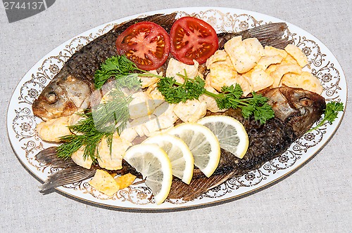 Image of Fresh crucian river fish fried in lemon juice and fresh herbs.