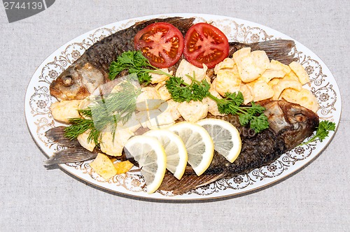 Image of Fresh crucian river fish fried in lemon juice and fresh herbs.