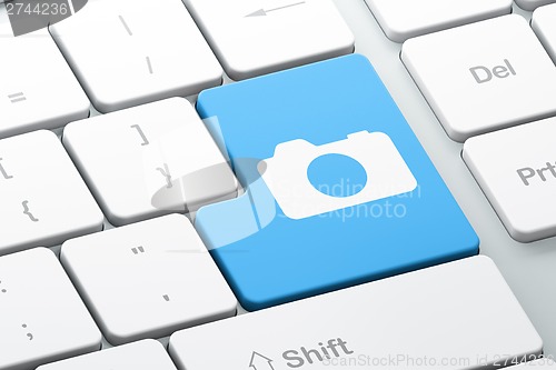 Image of Travel concept: Photo Camera on computer keyboard background