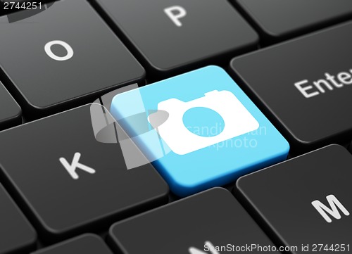 Image of Travel concept: Photo Camera on computer keyboard background