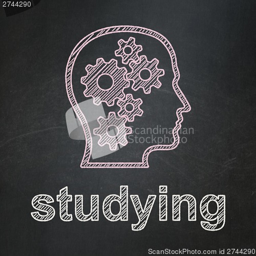 Image of Education concept: Head With Gears and Studying on chalkboard background