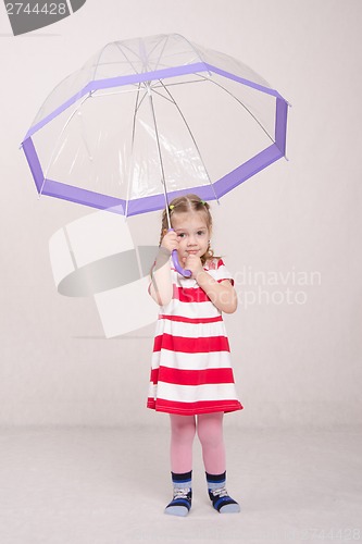 Image of Three year old girl raised her umbrella