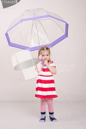 Image of Three year old girl raised her umbrella