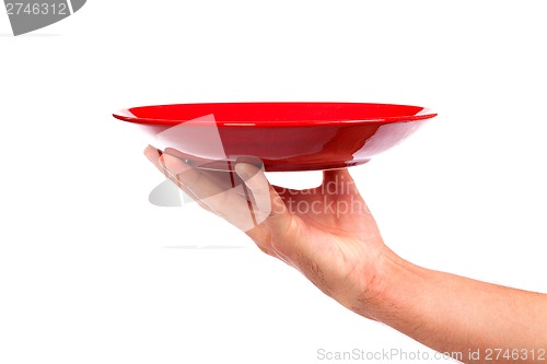 Image of Red kitchen plate on a hand isolated