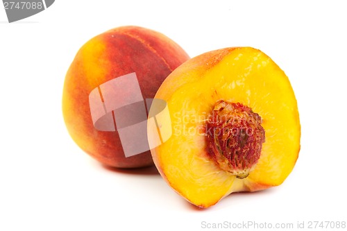 Image of Three perfect, ripe peaches with a half  and slices isolated on 