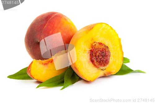 Image of Three perfect, ripe peaches with a half  and slices isolated on 