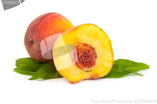 Image of Three perfect, ripe peaches with a half  and slices isolated on 