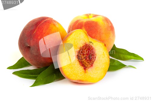 Image of Three perfect, ripe peaches with a half  and slices isolated on 