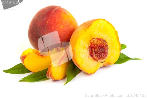 Image of Three perfect, ripe peaches with a half  and slices isolated on 