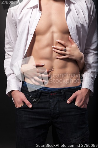 Image of Woman's hands on a sexy man's torso