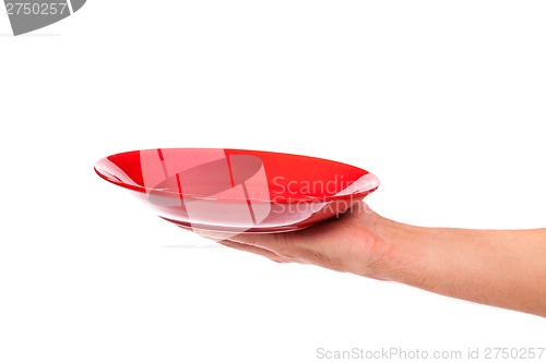 Image of Red kitchen plate on a hand isolated