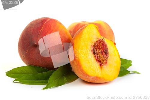 Image of Three perfect, ripe peaches with a half  and slices isolated on 