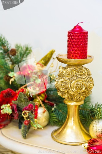 Image of A fireplace mantle is decorated for Christmas with garland, ligh