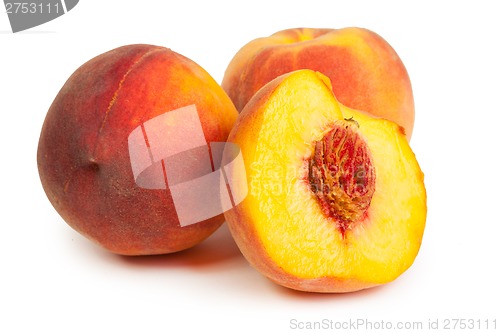 Image of Three perfect, ripe peaches with a half  and slices isolated on 