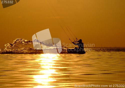 Image of Silhouette of a kitesurf on a gulf on a sunset