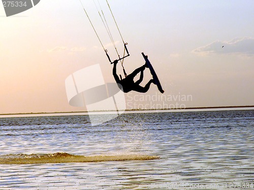 Image of Silhouette of a kitesurf, a flying above water of a gulf