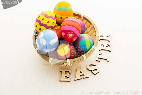 Image of Easter egg in basket with wooden text