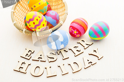 Image of Colourful easter egg in basket with wooden text