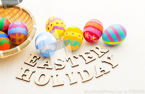 Image of Colourful easter egg in basket and wooden letter