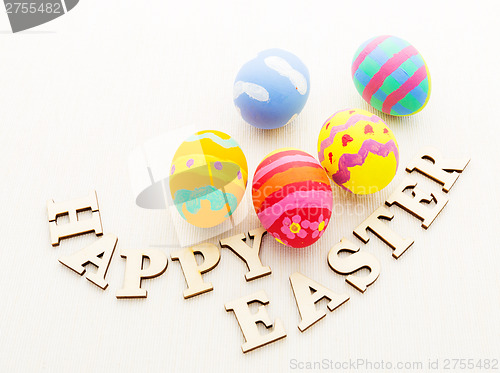 Image of Painted easter egg with wooden text on linen background