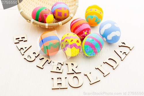 Image of Painted easter egg in basket with wooden text