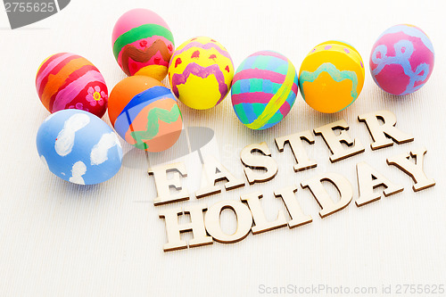Image of Colourful painted easter egg with wooden text